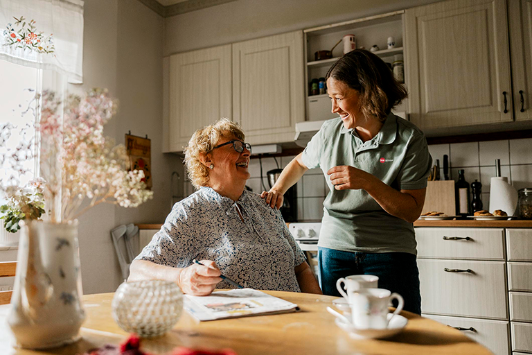 CCA member sitting in her kitchen while talking to a CCA care team member